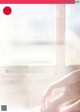 A woman is sitting on a window sill with her legs crossed.