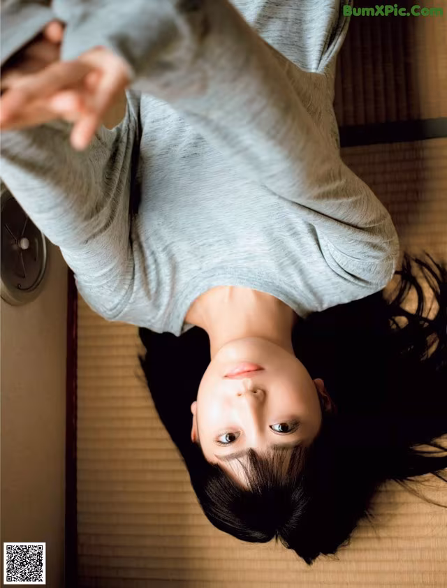 A woman laying on the floor with her arms outstretched.