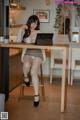 A woman sitting at a table with a cup of coffee.