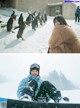 A woman sitting in the snow next to a group of penguins.