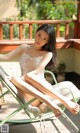 A woman sitting in a chair on a deck.