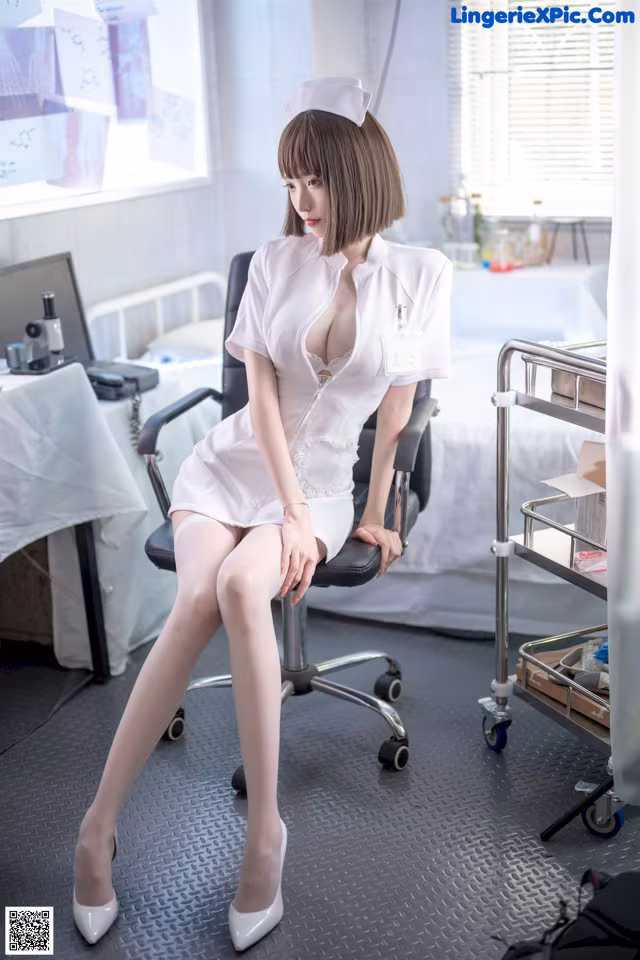 A woman in a white dress sitting on a chair.