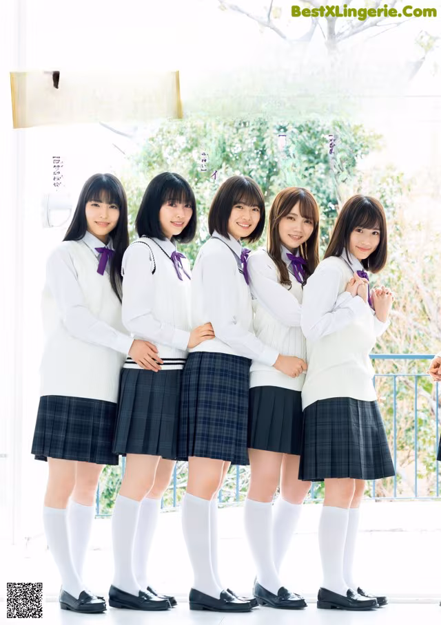 A group of young women in school uniforms posing for a picture.